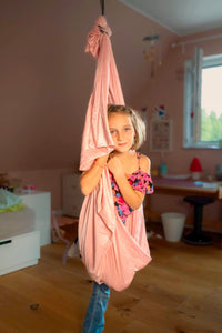 Nubbli Therapieschaukel Powder Pink im warmen Kinderzimmer