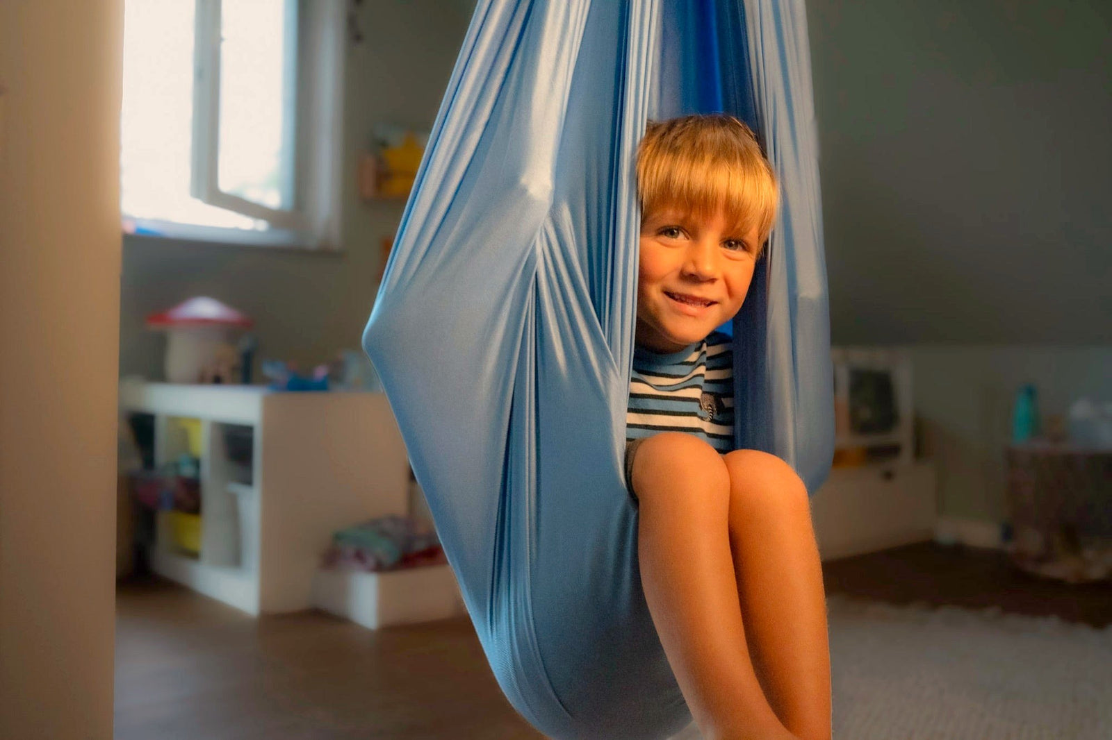 Nubbli Aufbau Schritt 5: Kind sitzt entspannt in der fertig aufgehängten Therapieschaukel